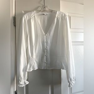 Creamy white polyester blouse with elastic detail at waist.